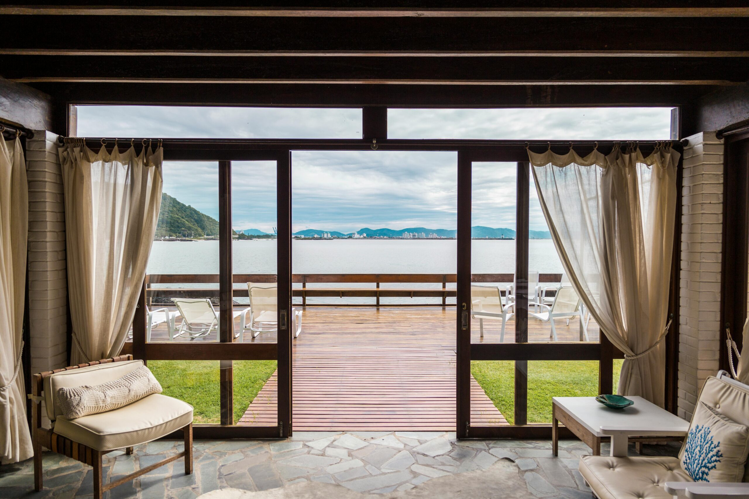 Elegant room with ocean view from large windows overlooking the beach in Brasil.